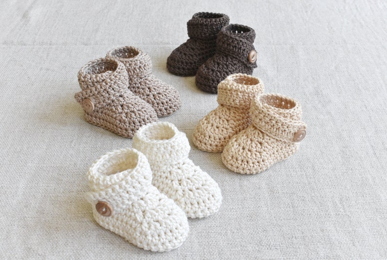 Pode incluir: Seis pares de botinhas de beb&eacute; em croch&ecirc; em castanho, bege e branco com um detalhe de bot&atilde;o. As botinhas s&atilde;o feitas com um padr&atilde;o de ponto texturizado.