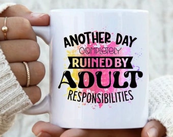 Könnte beinhalten: Weiße Keramiktasse mit einem bunten Aquarellhintergrund und schwarzem Text, der "Another day completely ruined by adult responsibilities." lautet.
