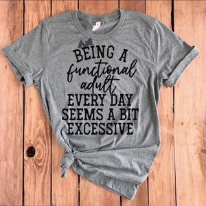 May include: Gray t-shirt with black text that reads "Being a functional adult every day seems a bit excessive."