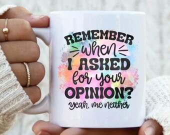 Könnte beinhalten: Eine weiße Keramiktasse mit einem bunten Aquarellhintergrund und schwarzem Text, der "Remember when I asked for your opinion? Yeah, me neither." lautet.