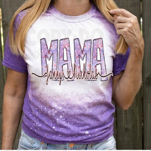 May include: Purple and white tie-dye t-shirt with the word "MAMA" in sparkly pink and purple letters. The text "Johnny & Nicholas" is written below in black cursive with a heart symbol.