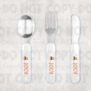May include: A three-piece children's flatware set featuring a spoon, fork, and knife. Each piece has a white handle with the name "Joey" in orange and a cartoon image of a hat. The utensils are made of stainless steel.
