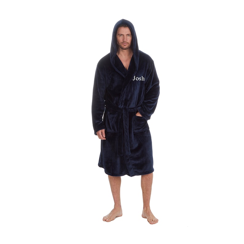 May include: A navy blue hooded robe with a white embroidered name "Josh" on the left side. The robe has a tie belt and two pockets.