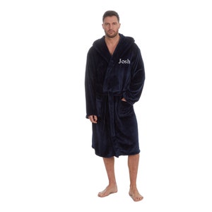 May include: A navy blue hooded robe with a white embroidered name "Josh" on the front.