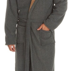 May include: A gray waffle knit robe with a brown sherpa lining and a hood. The robe has a belt and two pockets. The name "Josh" is embroidered on the robe.