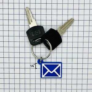 Peut inclure: Un porte-cl&eacute;s en forme d'enveloppe bleue avec un anneau de cl&eacute; argent&eacute; et deux cl&eacute;s. Les cl&eacute;s ont des t&ecirc;tes en plastique noir avec le texte "DB" et "030" dessus. Le porte-cl&eacute;s mesure 1/4 de pouce de long.