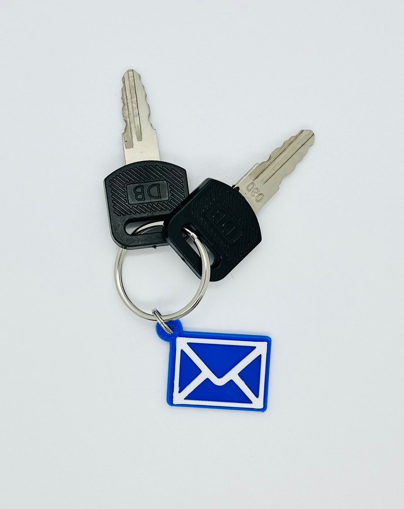 Peut inclure: Deux cl&eacute;s argent&eacute;es avec des t&ecirc;tes en plastique noir attach&eacute;es &agrave; un porte-cl&eacute;s argent&eacute; avec un charme enveloppe bleu. Les cl&eacute;s portent les inscriptions "DB" et "080" sur les t&ecirc;tes.