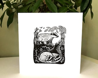 May include: Black and white linocut print of a badger and two cubs in a burrow. The print is on a white card with the text "Good Luck" written in a cursive font.