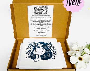 May include: A box of greeting cards featuring a black and white illustration of a woman sitting with her legs crossed. The illustration is surrounded by flowers and leaves. The text "Thank you for purchasing from my store." is printed on a card inside the box.