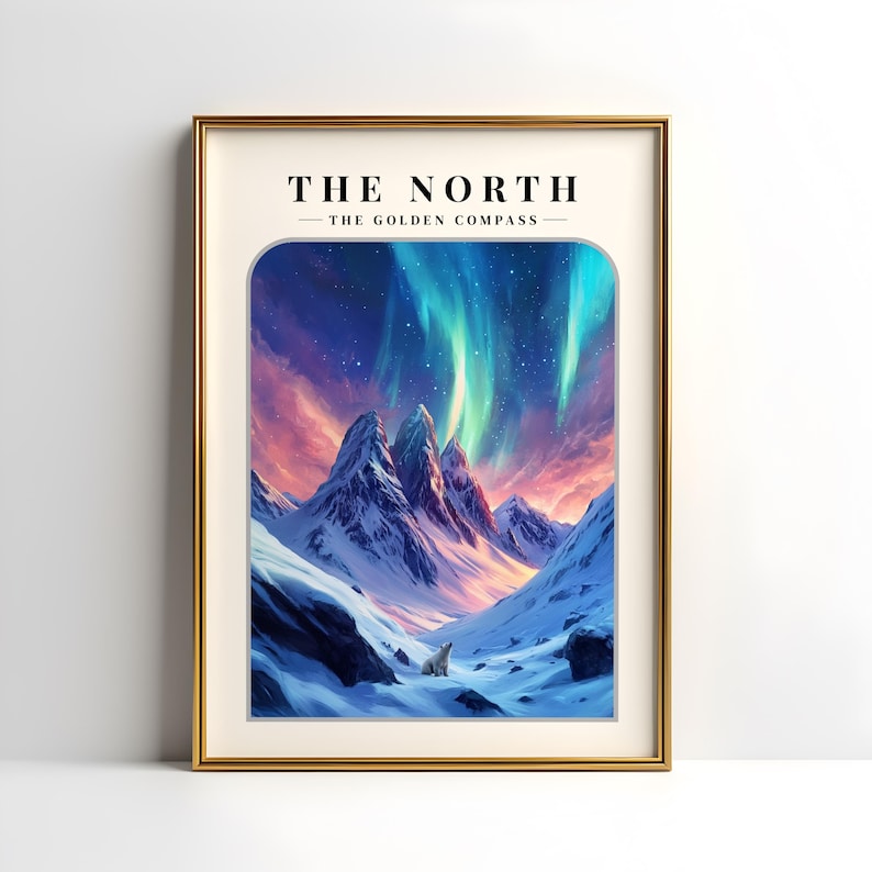 May include: A framed print with the text "THE NORTH - THE GOLDEN COMPASS" at the top. The image shows a snowy mountain range with a polar bear in the foreground and a vibrant aurora borealis in the sky.