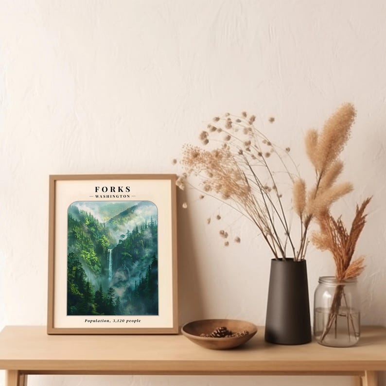 May include: A framed vintage-style poster with a watercolor illustration of a waterfall in a lush green forest. The poster has the text "FORKS - WASHINGTON" and "Population: 3,120 people" at the top and bottom, respectively.