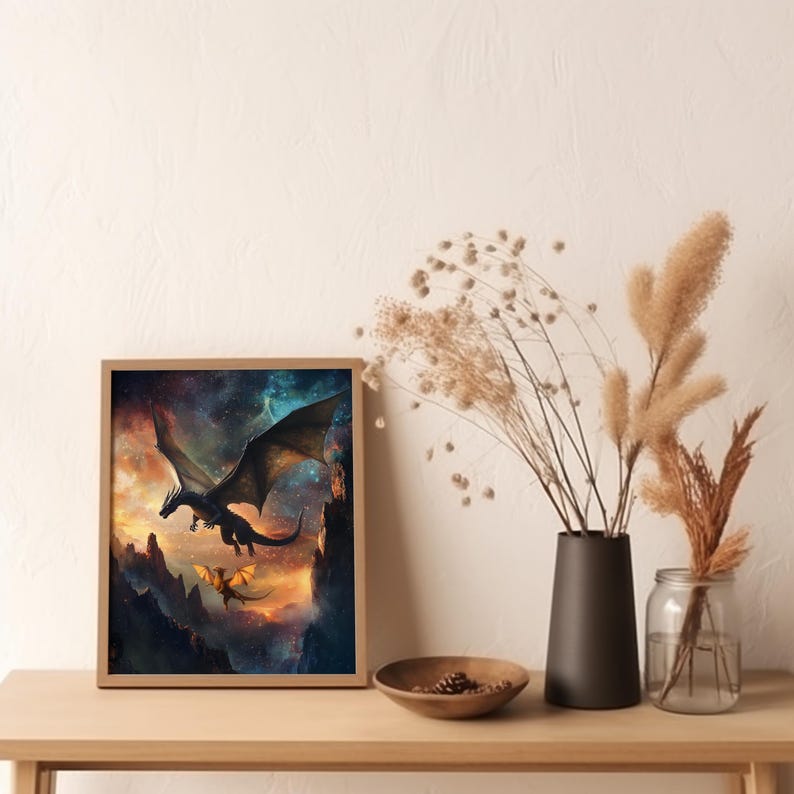 K&ouml;nnte beinhalten: Ein gerahmter Druck eines schwarzen und blauen Drachen, der durch einen sternenklaren Himmel fliegt, mit einem kleineren, goldenen Drachen, der hinter ihm fliegt. Die Drachen fliegen &uuml;ber eine felsige Landschaft.