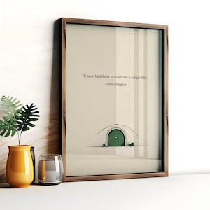 May include: A framed art print featuring a quote by Bilbo Baggins: "It is no bad thing to celebrate a simple life." The artwork depicts a hobbit hole with a green door. The frame is a dark wood color.