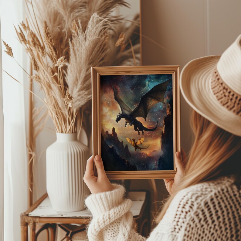 K&ouml;nnte beinhalten: Ein gerahmter Druck eines schwarzen Drachen, der in einem sternenklaren Himmel fliegt, mit einem kleineren goldenen Drachen, der darunter fliegt. Der Druck ist in einem Holzrahmen mit einem wei&szlig;en Passepartout.