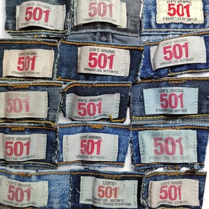 May include: A close-up of several denim patches featuring the Levi's 501 logo. The patches are in various shades of blue and display the text "Levi's Original" and "Straight Leg Button-Fly".