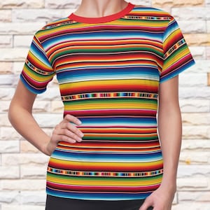May include: A short-sleeve t-shirt featuring a vibrant, multi-colored horizontal striped pattern in shades of red, yellow, blue, green, and white. The garment has a solid red crew neckline and a fitted silhouette, providing a colorful appearance.