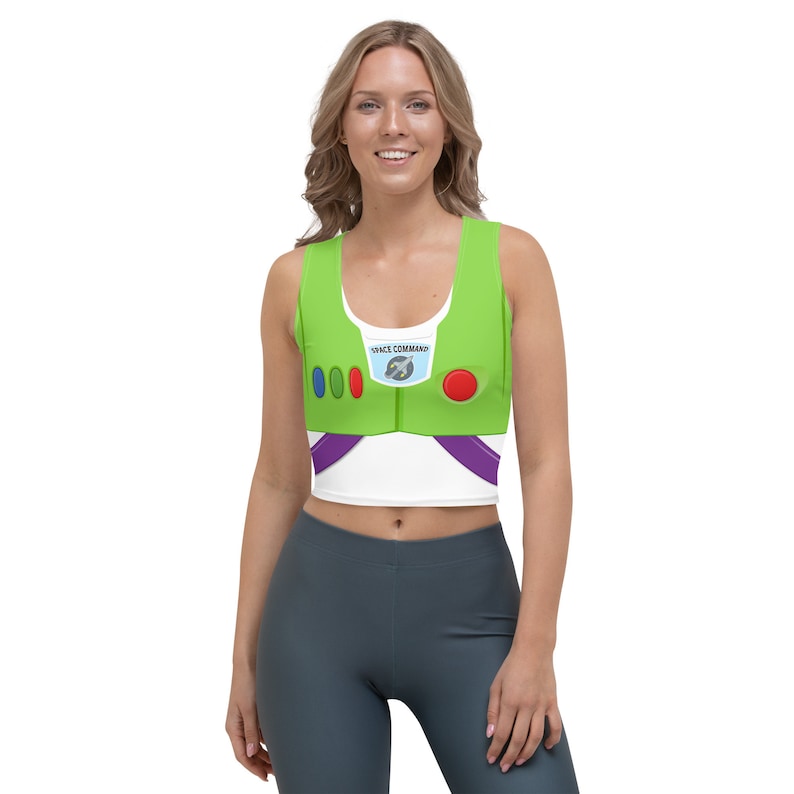 May include: A green and white crop top with a design inspired by the character Buzz Lightyear. The top features a green front with a white chest area, purple accents, and the words "SPACE COMMAND".