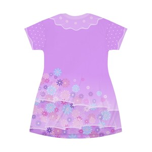 May include: A short-sleeved dress in a light purple hue featuring a scalloped collar with small white floral accents. The sleeves have a white polka dot pattern, and the lower portion of the dress displays a dense print of blue and pink flowers.