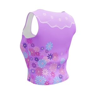 May include: A sleeveless lavender tank top featuring a scalloped white neckline detail and a vibrant floral pattern across the lower section. The print consists of various stylized flowers in shades of light blue, dark blue, pink, and magenta.