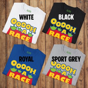 Puede incluir: Cuatro camisetas de manga corta y cuello redondo en blanco, negro, azul real y gris deportivo. Cada camiseta presenta el texto "OOOOH, A RACE" en amarillo y azul, acompa&ntilde;ado de tres gr&aacute;ficos de personajes alien&iacute;genas verdes y una base roja.