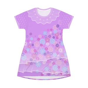 May include: A short-sleeve dress in a light purple hue featuring a round neckline with a ruffled collar detail. The garment is decorated with a scattered floral pattern in shades of blue, pink, and purple, with a polka dot print on the sleeves.