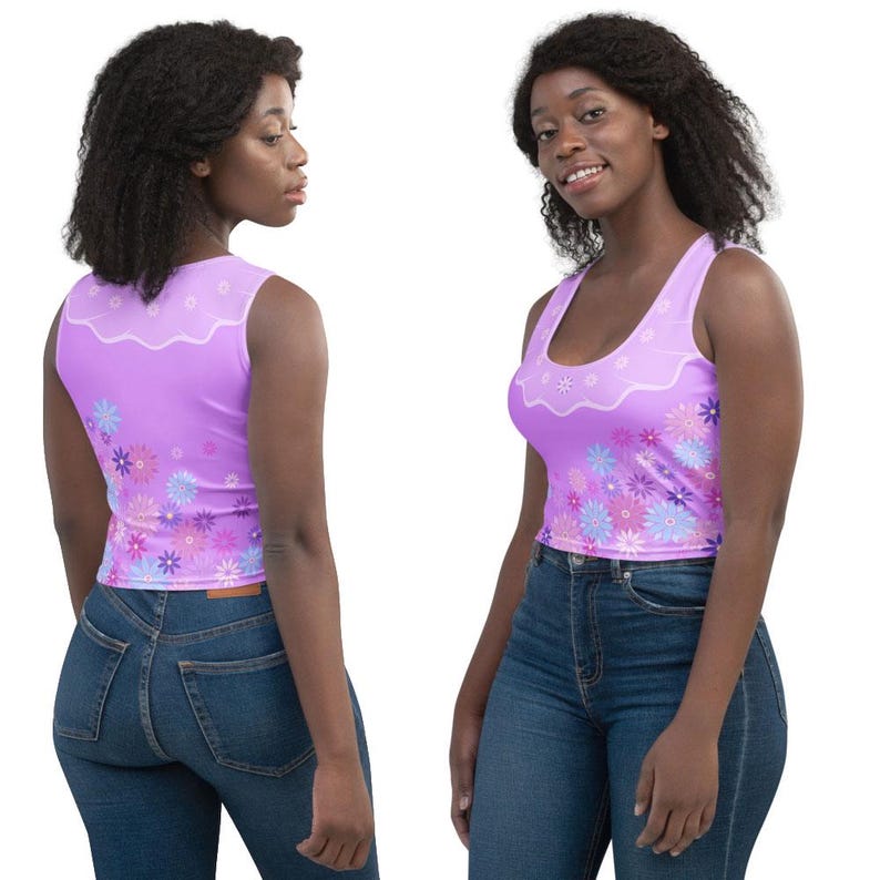 May include: A sleeveless lavender crop top featuring a scalloped white neckline detail and a vibrant floral pattern in shades of pink, purple, and blue. The garment is shown from both the front and back views, paired with dark blue denim jeans.