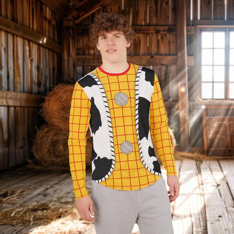 May include: A long-sleeved shirt featuring a yellow and red grid pattern, a white and black cow-print vest overlay, and two circular silver buttons on the front. The shirt has a round red neckline and is worn with plain light gray pants.
