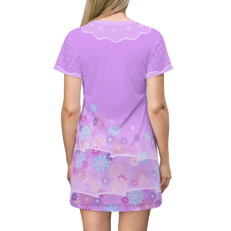 May include: A short-sleeve lavender t-shirt dress featuring a white scalloped collar design at the neckline and white polka dots on the sleeves. The lower portion of the dress displays a dense pattern of light blue, purple, and pink flowers.