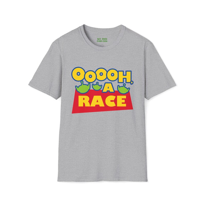 Puede incluir: Una camiseta gris jaspeado de manga corta con un estampado gr&aacute;fico que incluye el texto Ooooh, A RACE en letras amarillas y rojas. Tres cabezas de alien&iacute;genas verdes se sit&uacute;an sobre la palabra RACE. La etiqueta interior dice WE RUN FOR FUN.