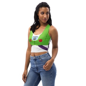 May include: A green, white, and purple crop top with a design inspired by the character Buzz Lightyear. The top features the words "SPACE COMMAND" and red and green accents. The top is sleeveless and made of a soft material.
