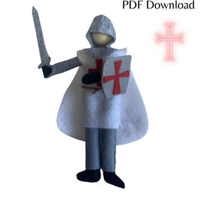 Puede incluir: Un patrón de muñeca de fieltro para un caballero templario, con una túnica blanca, pantalones grises, un escudo con una cruz roja y una espada. El patrón está disponible para descargar en PDF. El texto "Templar Knight" y "PDF Download" está en la parte superior de la imagen. Una cruz roja está en la esquina superior derecha. El texto "Make your own Templar Knight doll from felt" y "Pattern By The Woolly Witch" está en la parte inferior de la imagen.