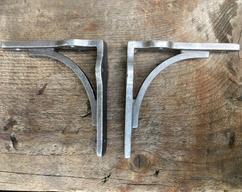 A pair of small solid industrial style cast iron brackets