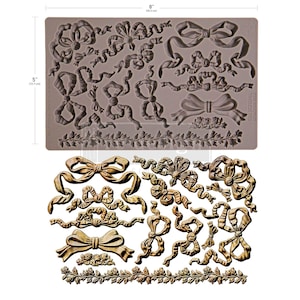 May include: A gray silicone mold featuring various bow designs and a floral border. The mold measures 8 inches (20.3 cm) wide and 5 inches (12.7 cm) high. The image also shows a sample of the bows in a metallic gold color.