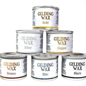 May include: Six small metal containers of gilding wax in different colors: gold, silver, copper, bronze, zinc, and black. Each container has a label that reads "Gilding Wax" and the color of the wax.