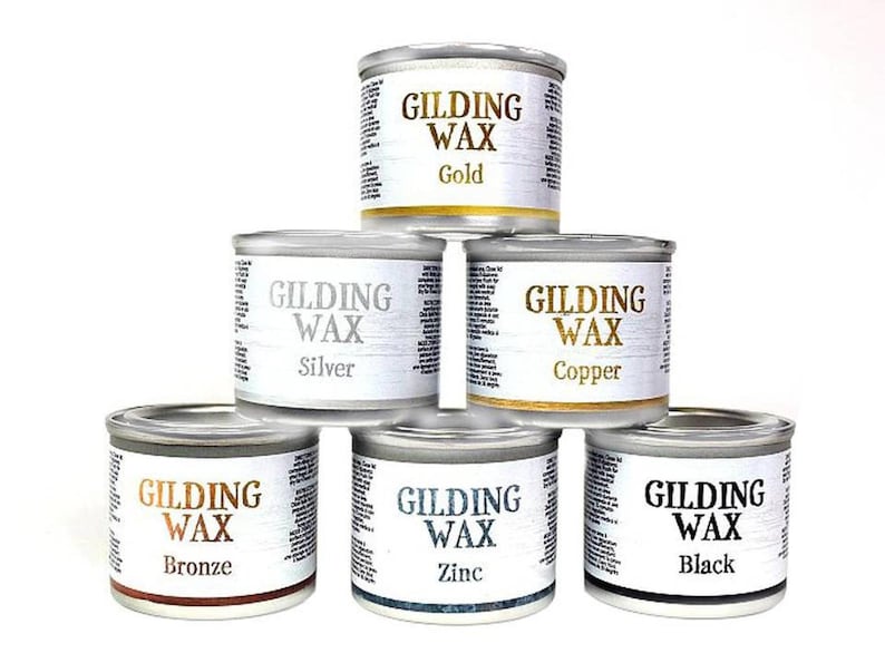 May include: Six small metal containers of gilding wax in different colors: gold, silver, copper, bronze, zinc, and black. Each container has a label that reads "Gilding Wax" and the color of the wax.