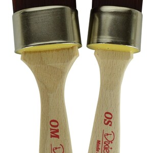 May include: Two Dixie Belle paint brushes with wooden handles and gold metal ferrules. The brushes are labeled "OS Dixie Belle Made in USA" and "OM Dixie Belle Made in USA".