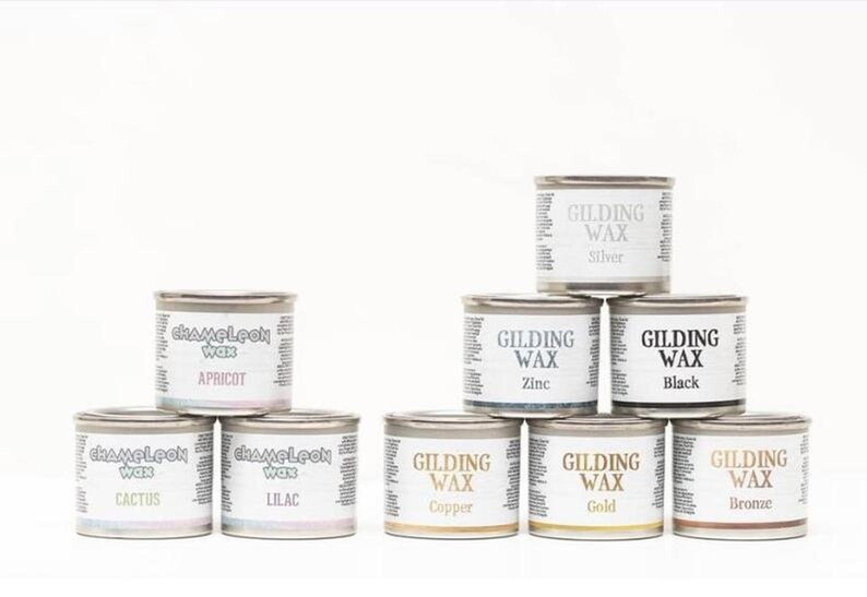 May include: Assortment of 10 small metal tins of wax for gilding and antiquing projects. The tins are labeled with the wax color, including Apricot, Cactus, Lilac, Copper, Gold, Silver, Zinc, Black, and Bronze.