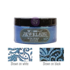 May include: A blue jar of Art Anthology Jewel Effect Paste in the color Blue Opals. The jar is labeled with the product name and size, 3.4 fl. oz. (100 ml). The paste is shown applied to a white and black surface.