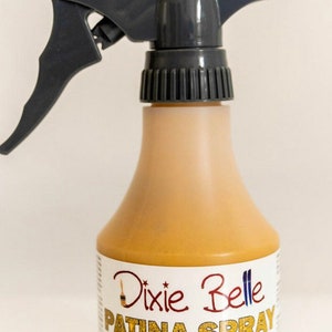 May include: A yellow spray bottle labeled "Dixie Belle Patina Spray Yellow" with the text "8 oz | 237 ml" and instructions for use on bronze, copper, and iron.
