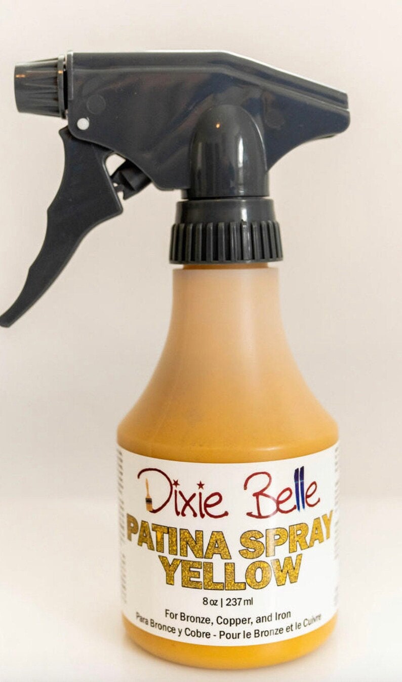 May include: A yellow spray bottle labeled "Dixie Belle Patina Spray Yellow" with the text "8 oz | 237 ml" and instructions for use on bronze, copper, and iron.