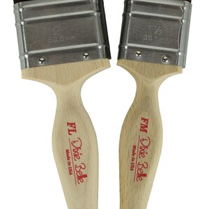 May include: Two wooden-handled paint brushes with silver ferrules. The brush on the left is 2 inches wide and the brush on the right is 1 1/2 inches wide. Both brushes are labeled "FM Dixie Belle Made in USA."