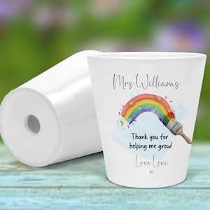 May include: White ceramic planter with a rainbow and paintbrush design. The text reads "Mrs Williams Thank you for helping me grow! Love Lexi x".