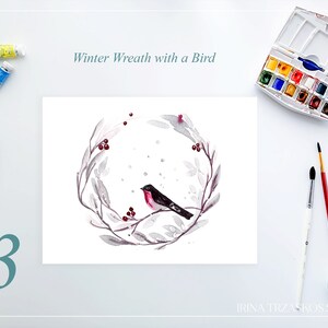 May include: Watercolor painting of a winter wreath with a bird. The wreath is gray with red berries and a black bird with a red breast. The text "Winter Wreath with a Bird" is above the painting. Paint tubes, pencils, and brushes are also visible.