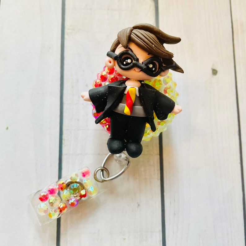 Red and gold Wizard boy clay doll badge reel