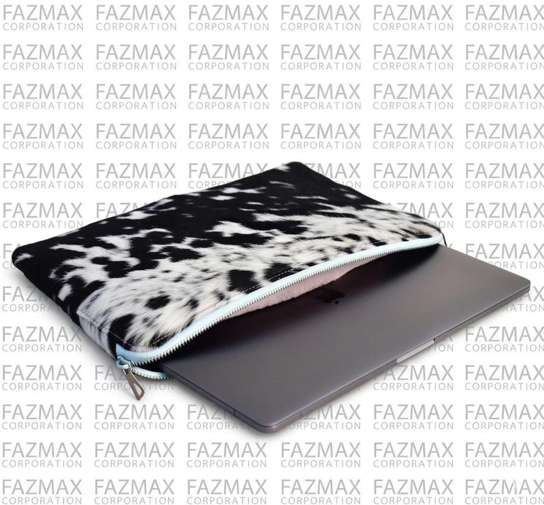May include: A laptop sleeve with a black and white cowhide pattern and a silver zip. A grey laptop is visible inside the open sleeve. The background has a repeating pattern of the words "FAZMAX CORPORATION".