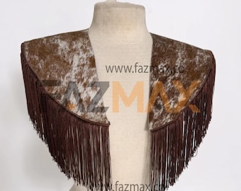 May include: A brown and white cowhide-patterned bolero jacket with long, dark brown fringe. The open-front jacket is displayed on a mannequin. The website address "www.fazmax.co" is visible in the image.