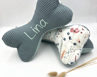 Puede incluir: Dos almohadas con forma de hueso de color gris y blanco. Una almohada tiene un patrón floral y la otra tiene el nombre "Lina" bordado.
