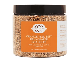 May include: A clear jar with a black lid contains orange peel zest dehydrated granules. An orange label displays the text "Civilized Coffee" and "Orange Peel Zest Dehydrated Granules". The net weight is 9 oz (255 g).