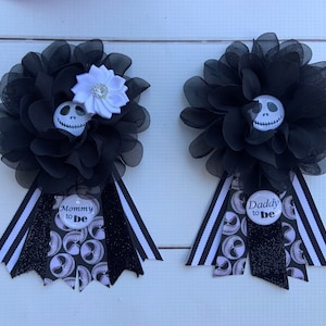 May include: Two black and white themed party favors with black and white striped ribbon. One favor has a white flower with a rhinestone center and says "Mommy to Be". The other favor says "Daddy to Be".