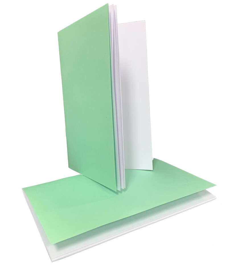 May include: A stack of blank cards with a light green cover and white interior. The cards are folded in half and are ready for writing.